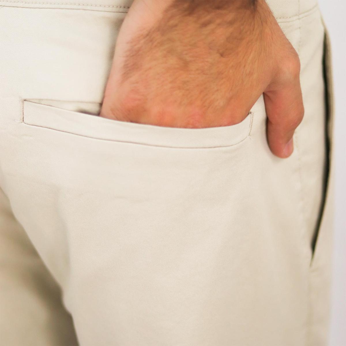 بنطال كاكي من قماش قطني/إيلاستين تويل، بخصر مطاطي منخفض وقصة مدببة.